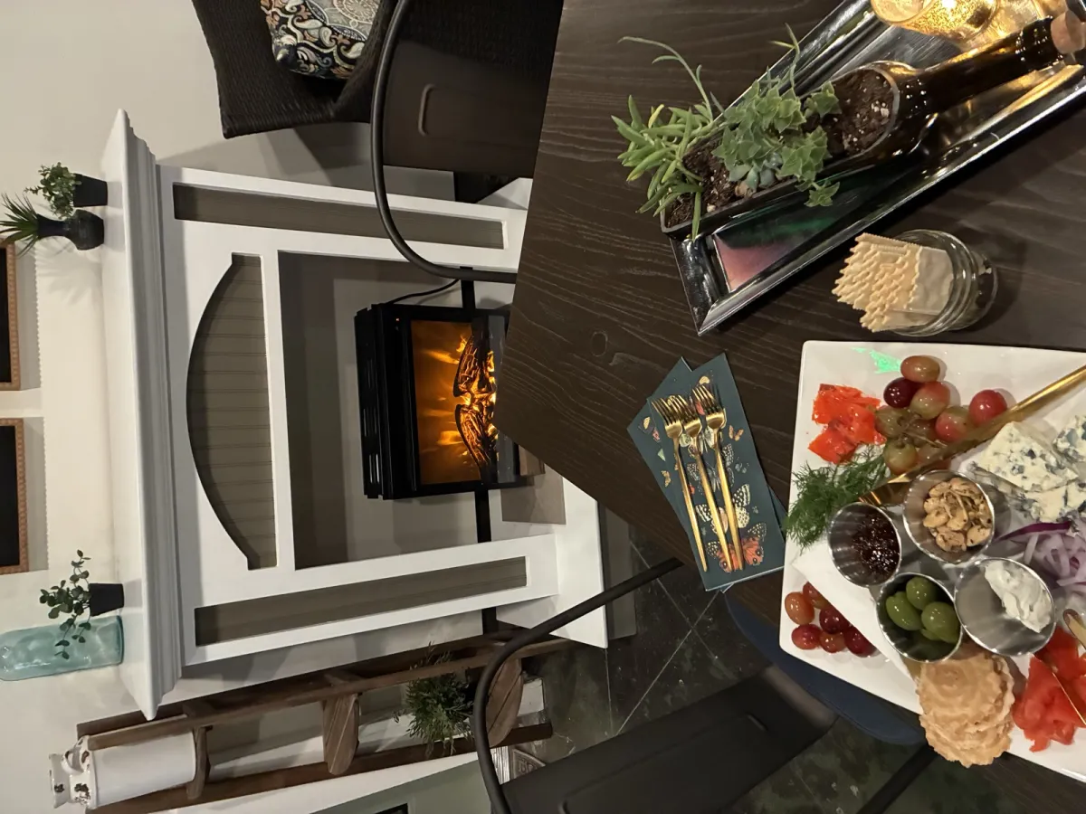 Charcuterie and salmon lox board with olives, grapes, nuts, and crackers by the fireplace