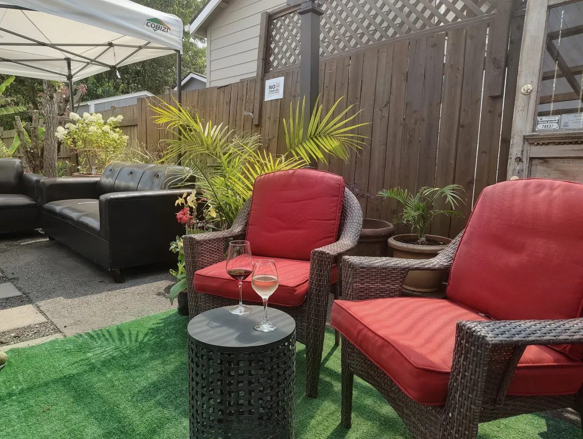 The Back Patio garden patio with red chairs, pergola, and seating